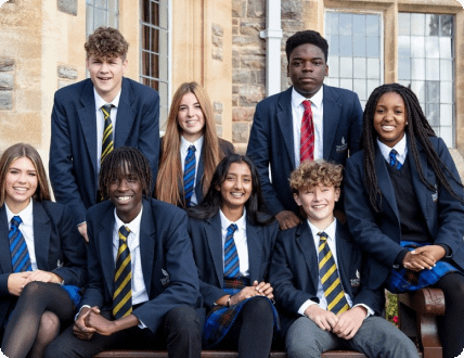 Eight students sitting and smiling while posing for a picture